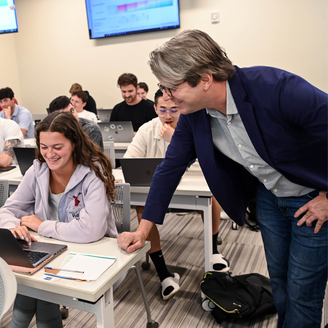 photo of AJ Brooks speaking with a student during a class